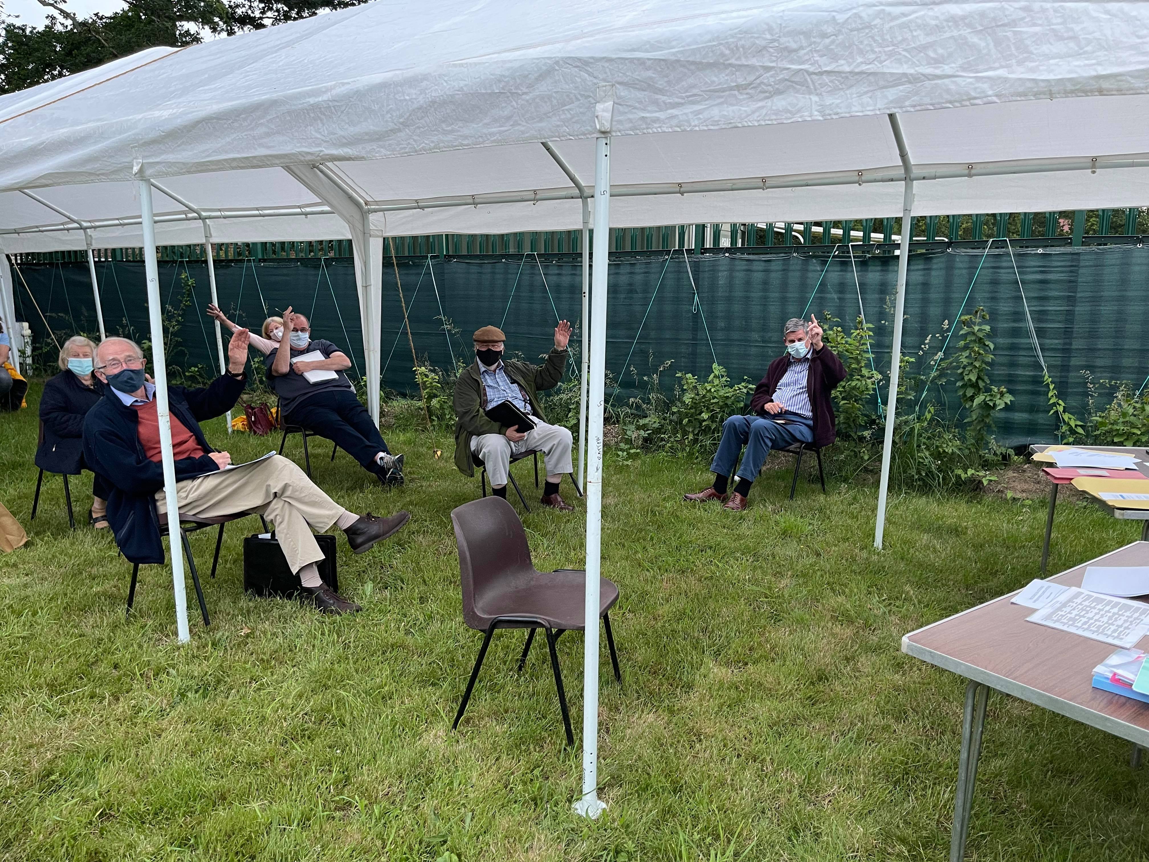 Outside meeting of the Full Council showing some councillors under tent shelter